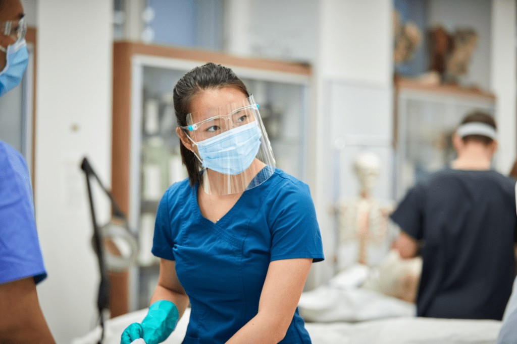 medical students in scrubs and face mask in an anatomy lab